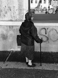 Rear view of woman with umbrella walking outdoors