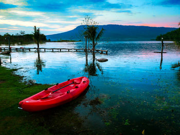 Boat moored on lake against sky