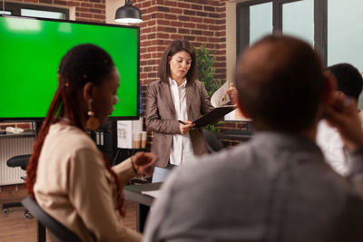 Businesswoman going through reports during meeting