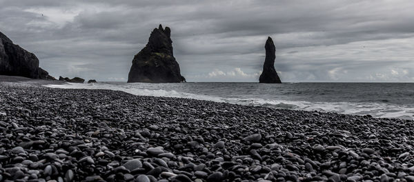 Rocks on beach against sky