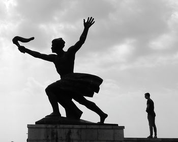 Low angle view of silhouette statue against sky