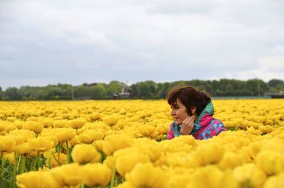 Woman with yellow flowers on field