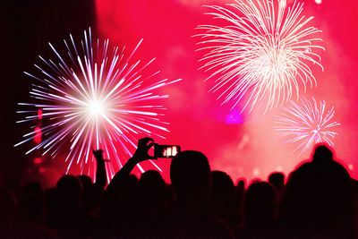 Crowd at music concert against firework during night