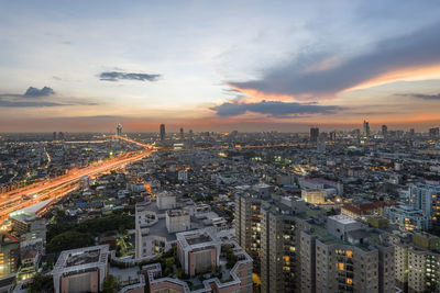 High angle view of illuminated cityscape against sky during sunset