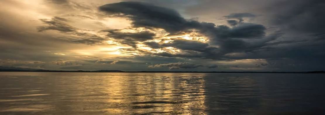 SCENIC VIEW OF SEA AGAINST CLOUDY SKY AT SUNSET