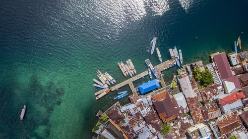 Aerial view of boats moored at harbor in sea