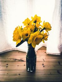 Close-up of yellow flower vase on table at home