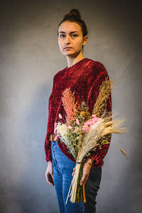 Portrait of beautiful woman standing against wall