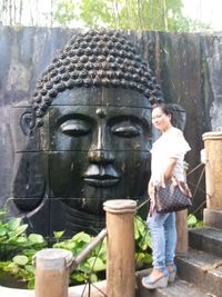 Full length of happy woman standing by statue