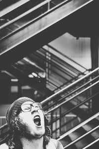 Young man screaming against staircase