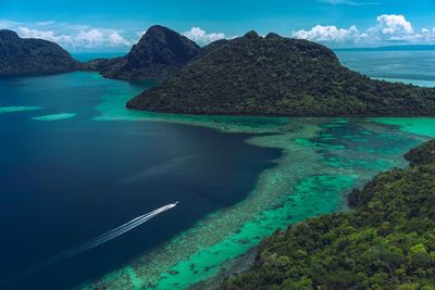 Scenic view of sea and mountains against sky