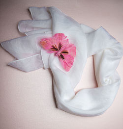 White silk scarf and pink butterfly brooch isolated on pink