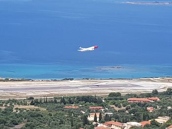 Airplane flying over sea against sky