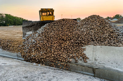 Earth mover at construction site against sky