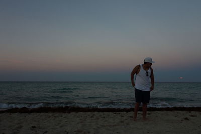 Full length of woman standing on beach against clear sky