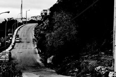 View of railroad tracks by road against sky