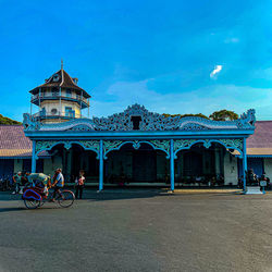 People in front of building against blue sky