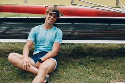 Portrait of a smiling young man sitting on grass