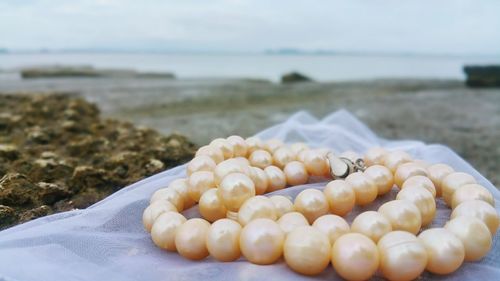 Close-up of pearl jewelry at beach