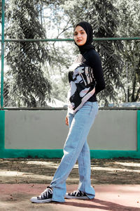 Full length of young woman standing in park