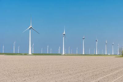 Windmill on field against blue sky, windmills by sea against sky, windmills park westermeerdijk