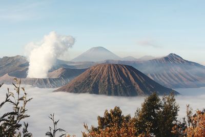 Smoke emitting from volcanic mountain against sky