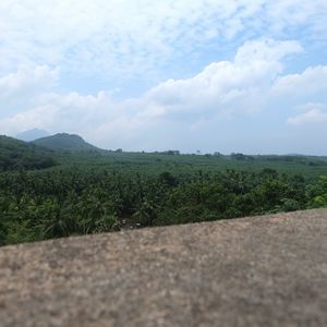 Scenic view of field against cloudy sky