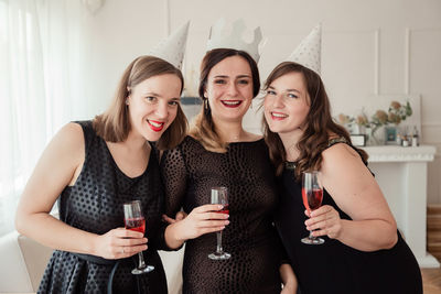 Portrait of smiling woman with friends celebrating at home