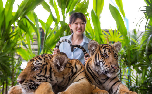 Portrait of woman with cat against plants