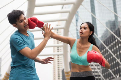 Woman punching man against railing