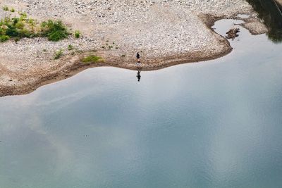 High angle view of man on rock by lake
