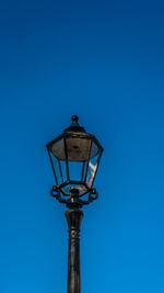 Low angle view of street light against blue sky