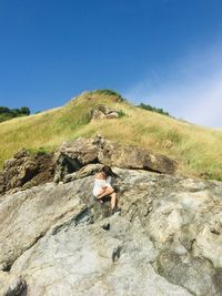 Man on rock against sky