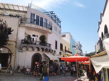 People on street against buildings in city