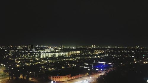 Illuminated cityscape against sky at night