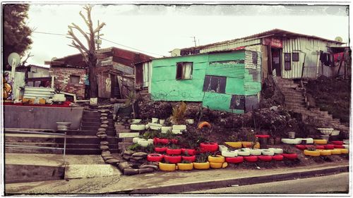 Multi colored houses by street against buildings in city