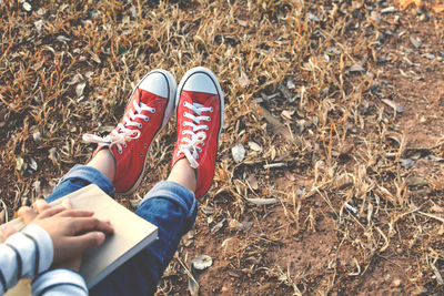 Low section of child with red canvas shoes