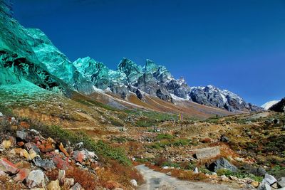 Scenic view of snowcapped mountains against clear blue sky