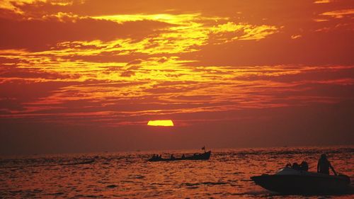 Silhouette sailboat in sea against sky during sunset