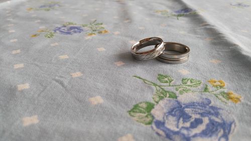 High angle view of wedding rings on bed