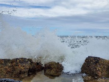 Rocks in sea against sky