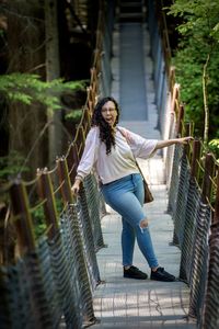 Full length of young woman walking on footbridge