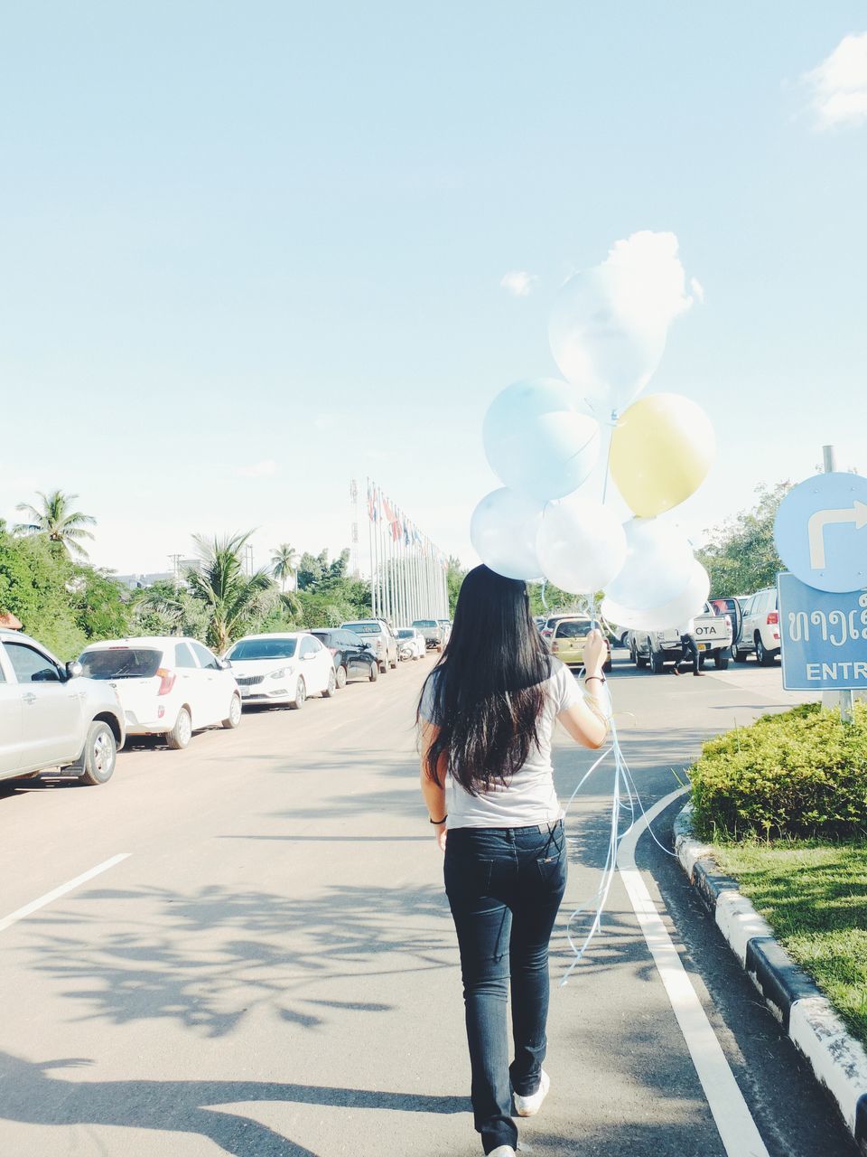 lifestyles, rear view, road, full length, transportation, leisure activity, street, casual clothing, tree, person, walking, sky, car, young women, sunlight, the way forward, long hair, standing