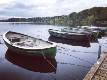 Boats moored on lake against sky