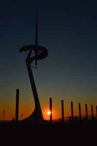 Low angle view of silhouette wooden post against sky during sunset