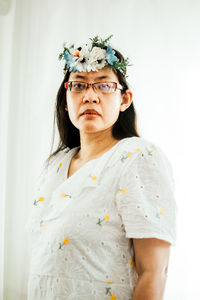 Portrait of woman wearing mask against white background