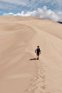 Man walking on sand dune in desert