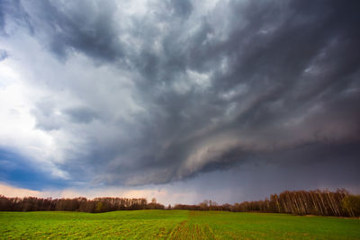 Scenic view of field against cloudy sky