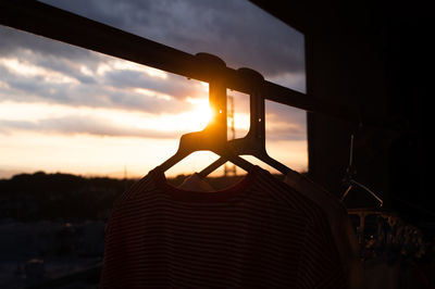 Close-up of silhouette railing against sky during sunset