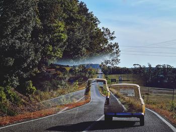 Cars on country road against sky